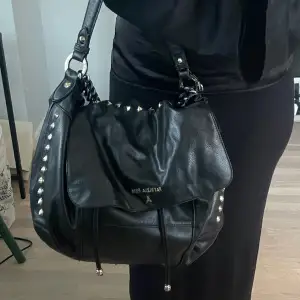 Snygg svart Patrizia Pepe handväska med nitar. Köpt på Sellpy därav äkthetskontrollerad💓 Bredd: 40cm, djup: 10cm, höjd: 25cm. Varan har använts flitigt och defekter förekommer. (Skriv för fler bilder)💓