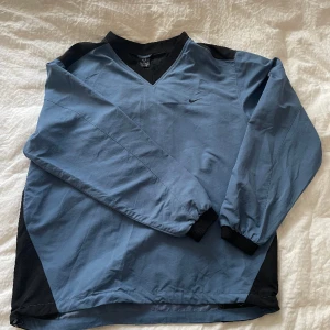 vintage nike windbreaker pullover :) - SÅ SNYGG oversized vintage nike tröja i vindmaterial i världens finaste kornblå färg!! den har stroppar att dra åt nedre sömmen med, en ficka, muddar och fin v-ringning. säljer då den är för stor på mig :) kom med frågor!! fler bilder finns 💕passar alla!