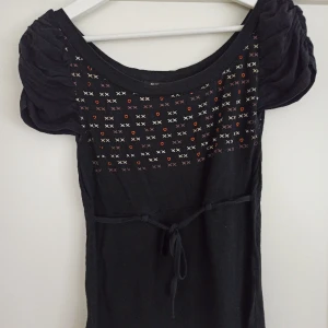 Svart och mönstrad babydoll topp - Svart och mönstrad babydoll topp storlek S/XS.  Av märket Euro's day Collection.  Har några skavanker vid snöret runt midjan, men annars fin.  Stretchigt material. 