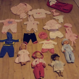 Dockor,dockkläder och två babylifts - Många fina aoutfits och dockor i bra skick.