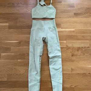 Oner Active set - Träningsset från Oner Active i ljusgrön färg. Inga inlägg i sport-bh:n och lite färgad på insidan samt lite skavanker baktill på tightsen och sprucket märke. Annars fint skick! Long lenght på tightsen.