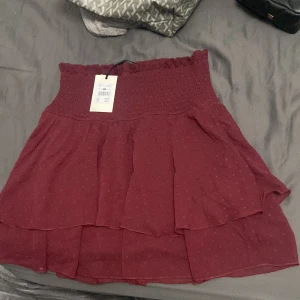 Volang kjol - Sjukt snygg vinröd/röd kjol köpt på bikbok, prislappen sitter kvar så den är aldrig använd. Säljer då jag inte använder kjol så mycket. Storleken är M men passar också S💕