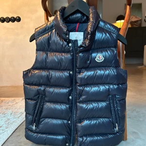 Moncler tib down gilet väst - Säljer min moncler tib gilet väst då jag växt ur den. Den är i absolut nyskick. Äkthet garanterad via QR-kod. Hör av er om ni vill ha fler bilder eller har frågor. Kvitto saknas tyvärr.  Storlek 14 years,storleken är som en XS vuxen.