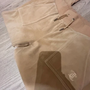 Beiga juicy byxor - Juicy byxor, lite nertrampade men inga andra skador, använda några gånger, priset går att diskutera men säljer inte för lägre än 600kr❣️❣️ Hör av er vid intresse! 