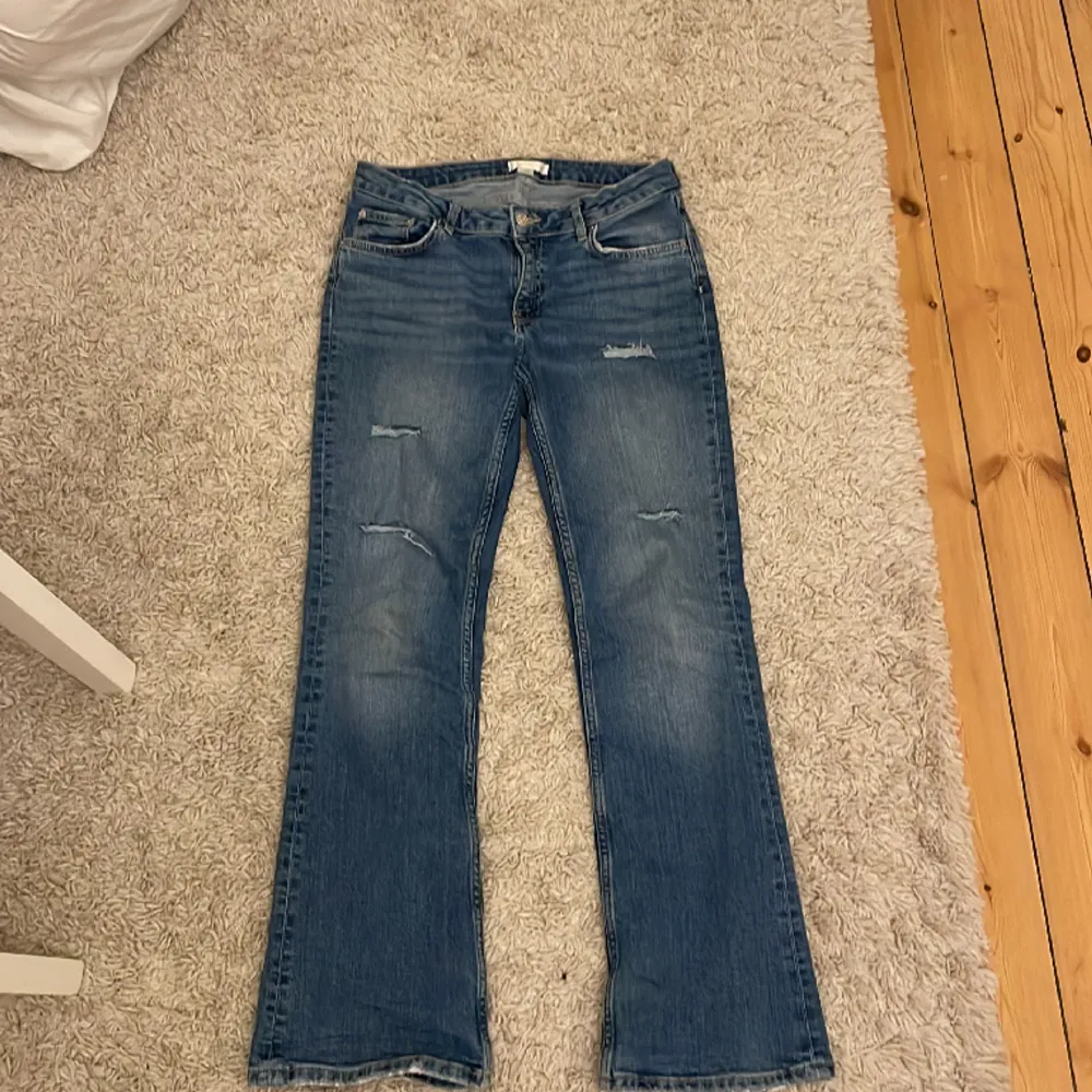 Jag säljer dessa super fina bootcut jeans med fina slitningar i stl XS/S. De har tyvärr slitits sig lite längst ner på byxorna där av priset, skriv för bilder 🫶Annars i jätte fint skick. Midjemått måttet: 36,5 cm raktöver, Innerbendslängden: 76 cm . Jeans & Byxor.