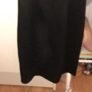 Svart kort klänning  - Svart kort klänning med tre öppna detaljer i bröstet, en genomskinlig halvrygg