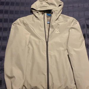 Haglöfs regnjacka - Oanvänd regnjacka med bra passform fin läng på armen och jysterbar luva och midja