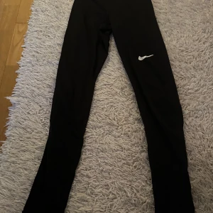 Nike träningstights - Säljer dessa träningstights från Nike i storlek XS. Tightsen är i bra skick förutom att texten på resonen högst upp har lossnat lite.