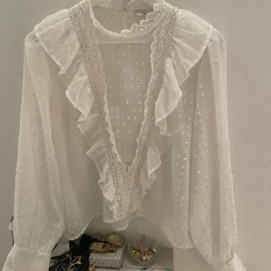 Blus med volanger  - Säljer denna blus med fina detaljer. Enbart använd två gånger, fint skick. Däremot finns svaga fläckar på höger arm, enligt bilderna. Syns knappt och går säkert att få bort🤍 Passar mig som vanligtvis bär storlek S