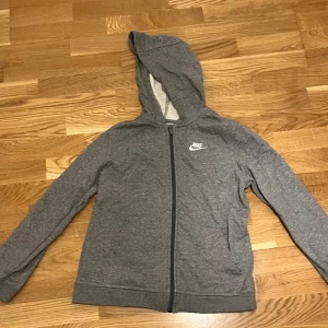 Mörk grå Nike zip hoodie - Storlek 147-158cm (L barn) väldigt bra skick, ligger bara i garderoben därför säljs den.