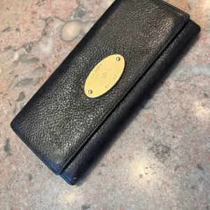 Mulberry plånbok i gott skick. Praktisk med många fack för kreditkort. På baksidan finns ett fack med dragkedja.