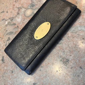 Äkta Mulberry plånbok i skinn - Mulberry plånbok i gott skick. Praktisk med många fack för kreditkort. På baksidan finns ett fack med dragkedja.