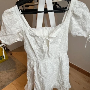Studentklänning  - Säljer min back up studentklänning. Använde inte denna så den är i väldigt bra skick! Superfin med små blommor, spets och snörningar i fram och armarna! Står inget märke eller storlek men skulle säga storlek 34/XS☺️ hör av dig om du har några frågor!