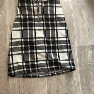 Rutig kjol med en låssas dragkedja  - En fin rutig kjol med en låssas dragkedja, ett resårband i midjan där back syns inte backifrån. Säljer för den är förliten. Priset kan diskuteras.