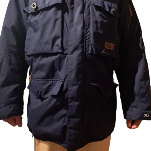 North Bend herrjacka Xl - Varm vinterjacka från North Bend storlek XL. Fint skick förutom ett hål i kragen på insidan jackan, inget som syns på utsidan. Många detaljer och fickor, dragsko i midjan.  Inköpt på Stadium för 999kr.  