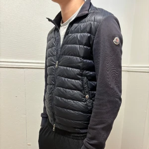 Moncler cardigan  - Hej, säljer nu min moncler cardigan då den blivit lite liten. Jacka är i topp skick förutom en väldigt liten slitning vi armkanten. Jackan är i storlek M men passar också S. Cond 8/10. Skriv vid intresse!