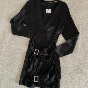 ZARA svart festklänning i satin med diamanter  - Otroligt snygg kavajklänning från ZARA i satin med två diamantsmycken. Aldrig använd, ny med tags kvar. Har eventuellt någon tråddragning men inget som är märkbart.