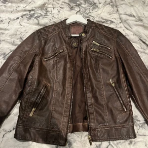 Brun skinnjacka - Säljer en cool skinnjacka med flera fina detaljer. Jackan är ifrån LIVELO och är i stl. 38. Knappt använd och säljer för 250kr+frakt. (Kan i vissa fall mötas upp)😊