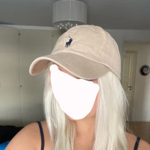 Ralph Lauren keps - Keps från Polo Ralph Lauren i populära färg. Aldrig kommit till användning och i nyskick. Inte säker på om den är äkta men är köpt i USA när jag var där (där av priset). Passar både killar och tjejer och går att skjustera storleken. NyPris äkta 450kr