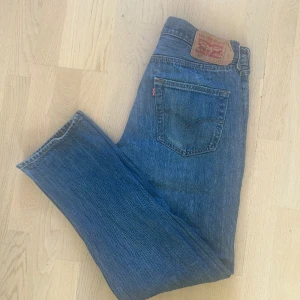 Levis jeans 501 - Ett par snygga retro jeans som passar på både män och kvinnor samt är lite slitna, annars är de i bra skick och storlek W33 L32