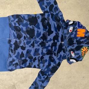 Bape hoodie  - Bape hoodie i färgen blå, skicket på hoodien är 8/10 och är lite använd. Priset är inte hugget i sten. Skriv till mig i dm för fler bilder eller svar på frågor. Checka in min profil för flera sjuka deals🤙💯