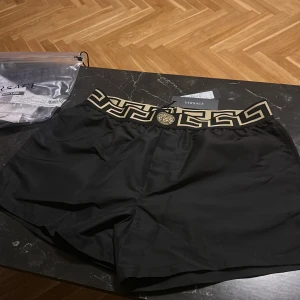 Versace shorts / bad byxor Strl L  - Här kommer perfekta shorts till våren/ sommaren äkta Versace shorts med tags, kvitto samt påse dom kommer i medföljer. Små i storleken får ej på mig dom över låren därför jag säljer helt oanvända!
