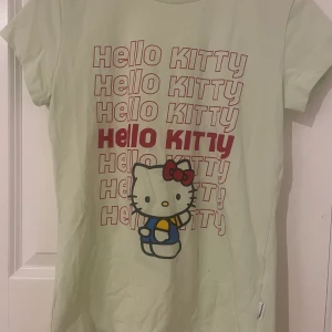 Hello Kitty t-shirt - Söt hello Kitty t-shirt som är nästan aldrig använt. Väldigt ljus grön med rött text 