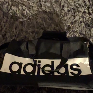 Adidas väska - Adidas väska. Funkar bra till allt speciellt gym eller som skolväska. Använd men k fint skick. 