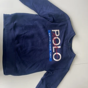 Ralph lauren tröja - Marinblå Ralph lauren tröja som är i bra skick utan några defekter. Tröjan är i storlek 14-16. Ursprungspris: 1000kr Vårt pris: 350kr