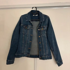 Jeansjacka  - Jeansjacka från Lindex, storlek 40-42. Skulle säga att den motsvarar en M. Använd men i fint skick! 160kr, köparen står för frakten 