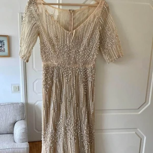 Klänning - Klänning sälj. Köpt o använd en gång. Storlek passar 34/36. Mycket pärlor på klänningen och färgen är mycket fin i verkligheten. Lång klänning. Pris 800kr