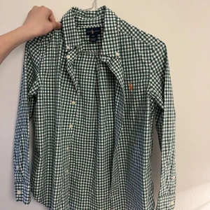 Snygg Ralph lauren skjorta - Så snygg oanvänd Ralph lauren skjorta som passar till alla tillfällen! Storlek 140 och köptes för ca 700kr, säljes för 150kr