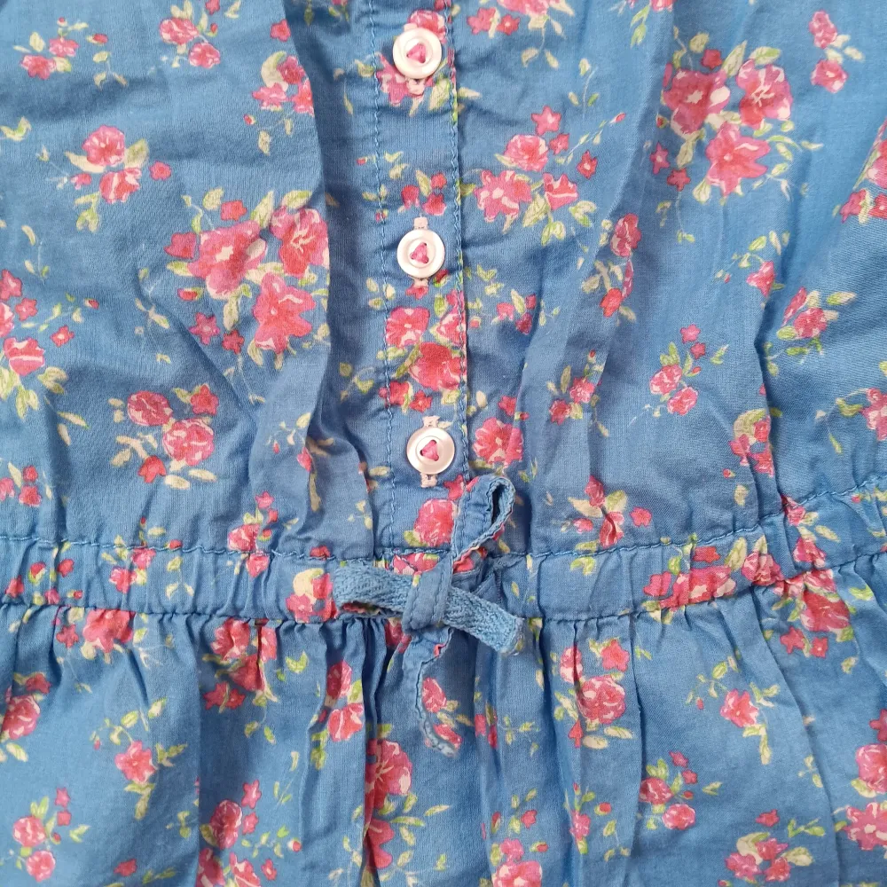 Blå klänning från H&M i blommigt mönster. Har en rosett band i midjan som kan jsutera storleken lite och fickor. Är i jättefint skick. Klänningar.