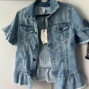 Jeansjacka  - Jeansjacka med kort ärm och volang. Den är helt oanvänd och har prislappen kvar. Storlek XS❤️ 