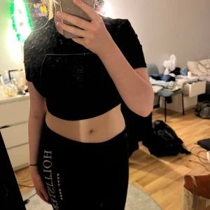 Svart crop top - En svart crop top med blått tryck. Från SHEIN i storlek M. Användes en del för två år sedan men känner att den har blivit lite liten. Väldigt skönt material.