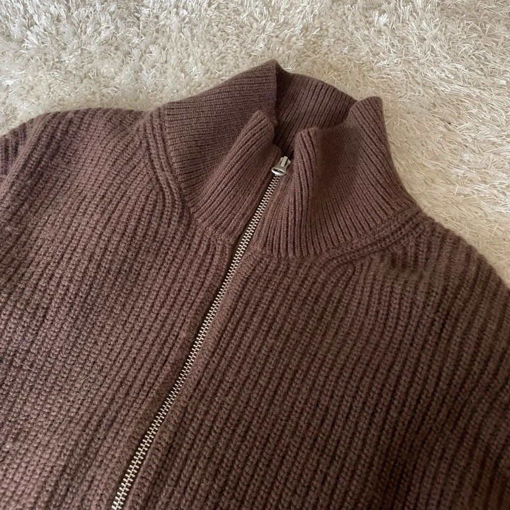 Brun stickad tröja från & Other Stories Brungrovstickad, ribbad sweatshirt i merinoullblandning med kort dragkedja💘varan är är lite nopprig. Nypris 1395kr🫶🏻. Tröjor & Koftor.