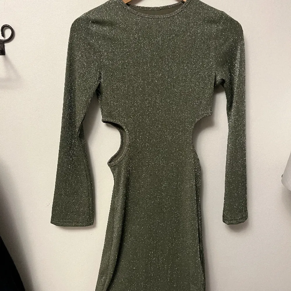 Glittrig grön klänning i storlek xs! Helt oanvänd då den köptes till nyår men blev aldrig använd!. Klänningar.