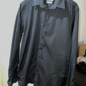 Svart skjorta - Svart skjorta i tailored fit från bläck (MQ). Storlek S. Jättefint skick. Extra knappar medföljes.