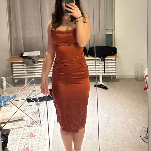 Satinklänning - Smickrande satinklänning i kopparfärg. Endast använd en gång!