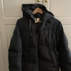 Arket- svart dunjacka  - Svart dunjacka (unisex storlek small) i 100% återvunnet dun. Använd två säsonger, den är hel. Nypris - 2000 sek.  Toppen om den kan hämtas i Vasastan Stockholm. 
