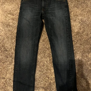 Lee Jeans - Säljer mina otroligt snygga och välbehållda mörkblåa jeans från Lee, inga defekter con: 10/10. Storlek 31/32 i modellen daren zip fly vilket är en blandning av slim och regular så passar folk mellan 175-180 cm lång. Nypris: 1200 Mitt pris: 349 kr