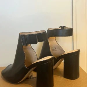 Svarta klackar i läder - Sköna, sparsamt använda, klackar i äkta läder. Silvrigt spänne. Nypris ca 1.100 kr