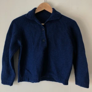 Croppad handstickad tröja - Croppad handstickad tröja i djupblå. Vackra knappar! Ärmarna är trekvarts. Mycket bra skick💙Skulle säga storlek XS/S!