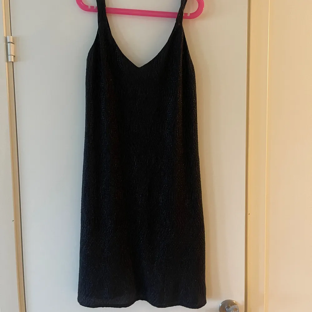 En kort svart skimrig klänning från Mango, strl S, aldrig använd. Klänningar.