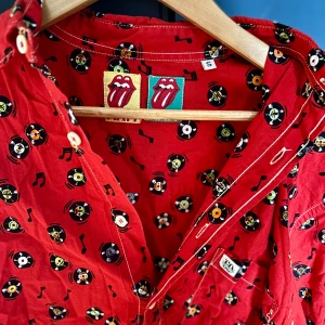 Vintage mönstrad röd skjorta - Skjorta med vinylskivor på. Storlek s. Köpt på humana men aldrig kommit till användning. Skicket är jättebra och den har inga anmärkningar. Snygga vita sömmar också. 100% bomull