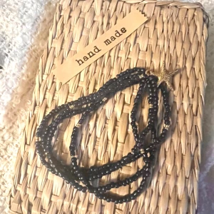 Armband  - Mörkblått 4-radigt armband på gummitråd men gulddetaljer 