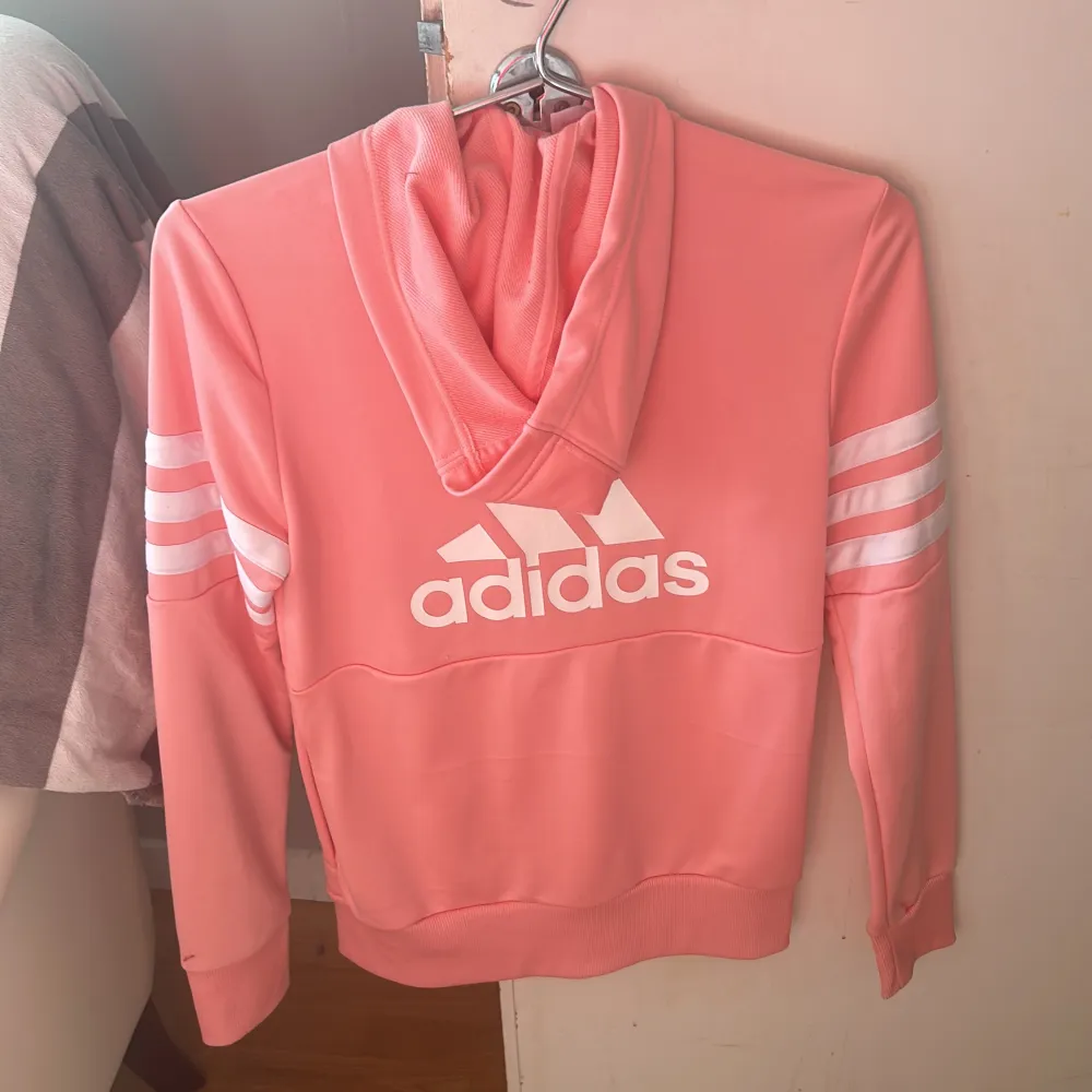 En rosa Adidas tröja i mer sportigt material i storlek 13-14 år (xs). Är i nytt skick och är använd 2-4 gånger . Hoodies.