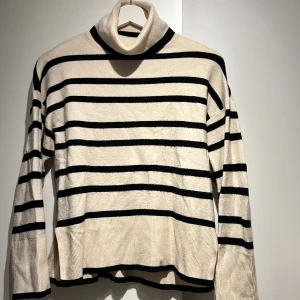 Långärmad randig stickad tröja  - Stickad randig tröja ifrån Veromoda. Med slits nertill på båda sidor. Polo-kragen är vikbar och kan anpassas hur man önskar. 