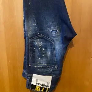 Blå jeans från Dsquared 2 med färgsplatter och slitningar. Bra skick och kvitto med mera finns.