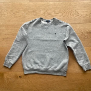 Ralph Lauren Tröja - En stilren Ralph Lauren sweatshirt i toppskick, den har endast varit vikt i garderoben och vecken på tröjan försvinner vid användning. Passar perfekt för någon med längden  170-175 cm. Vid ytterligare frågor, kontakta gjärna! 🛍️😊